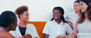 group of women in light and white clothing sitting and talking together